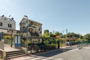 Zone d'accès au parking EFFIA Gare de Bois-le-Roi Nord avec abri vélos couvert et bâtiment fresque historique.