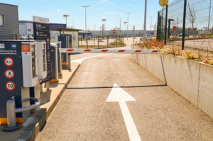 Zoom sur la voie de sortie du parking P2 Mâcon-Loché : l'infrastructure comprend des barrières automatiques, des bornes de paiement par carte et une signalétique tarifaire complète pour faciliter le départ des usagers.