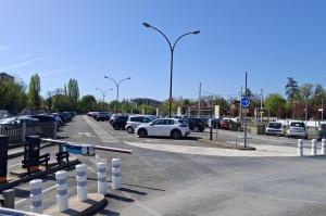 vue rapprochée de l'entrée d'un parking géré par EFFIA avec des bornes de contrôle et des barrières automatiques: le visuel met en avant la possibilité de réserver sa place de stationnement en ligne pour un départ serein.