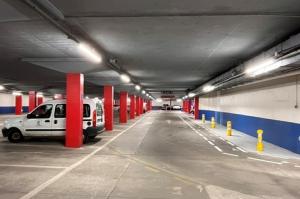Détail des équipements de contrôle d'accès à l'entrée du parking couvert EFFIA : la photo met en valeur la borne de ticket automatique, la barrière et l'interphone d'assistance pour les usagers.