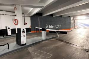 Rampe d'accès intérieure moderne et sécurisée reliant les niveaux du parking couvert EFFIA Diderot : un aménagement fonctionnel doté d'une signalétique directionnelle (flèches au sol) et de barrières de protection pour les piétons.
