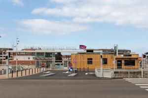 Entrée principale et bâtiment d'accueil en bois du parking EFFIA Gare de Thonon-les-Bains, avec portique d'accès et enseigne SNCF.