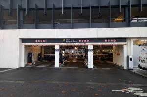 Entrée du parking EFFIA de la gare de Caen : accès multi-voies par barrière avec bornes de tickets sous la structure moderne du bâtiment.