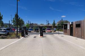 Vue d'une allée de circulation centrale au sein du parking extérieur EFFIA : un aménagement paysager propre et aéré doté de places de stationnement délimitées et d'arbres d'alignement pour le confort des usagers.