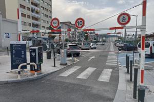 Accès principal du parking EFFIA Gare d'Aix-les-Bains : borne de distribution, portique de limitation de hauteur à 1,90 m et panneau des tarifs.