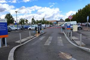 Voies d'accès et d'entrée du parking extérieur avec barrières automatiques.