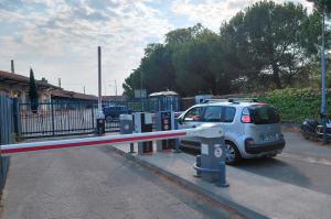 Bornes de péage, barrières levantes et véhicule en franchissement de l'accès sécurisé.