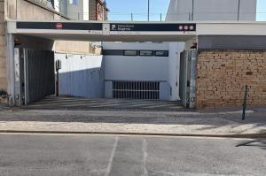 Entrée d'un parking pour abonnés Magenta, avec portail métallique ouvert.