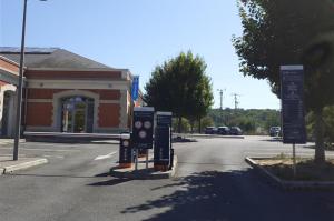 Bornes de contrôle d'accès, barrières automatiques et panneaux d'information à l'entrée du parking.