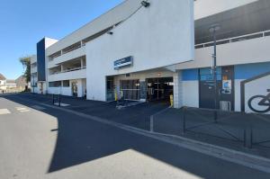 Façade du parking relais Persan-Beaumont montrant l'accès des véhicules et l'espace vélos.