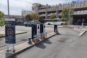 Borne de ticket et barrière d'accès à l'entrée du parking dépose-minute.