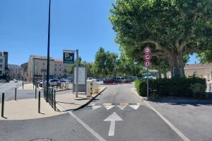 Voie d'accès au parking P2 équipée d'une signalétique lumineuse, de bornes d'entrée et d'une barrière automatique.