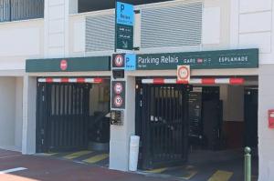 Entrée sécurisée du parking relais avec portes métalliques et signalisation.