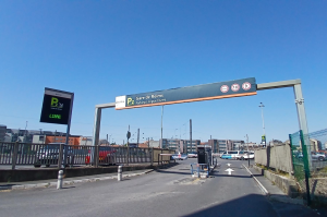 Portail d’accès, barrière automatique et portique de signalisation à l’entrée du parking.
