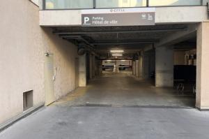 Entrée couverte du parking EFFIA Hôtel de Ville avec panneau de signalisation et barrière d'accès.