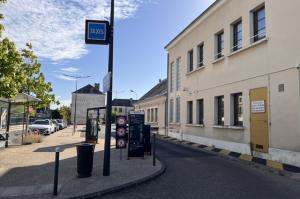 Voie d'accès au parking courte durée équipée d'un totem tarifaire, de barrières et d'une enseigne taxis.