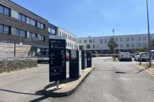 Entrée du parking du Village de Mercy avec panneau tarifaire EFFIA et barrière.