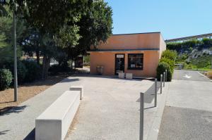 Local d'accueil EFFIA et parvis aménagé avec des bancs en béton devant le parking P1.