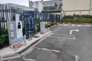 Borne de distribution de tickets, barrière automatique et panneau tarifaire à l'entrée du parking P2.
