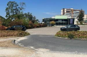 Vue sur le parking extérieur devant le bâtiment Espace Jean-Marie Poirier.