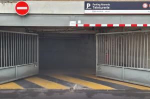Portail automatique métallique ouvert à l'entrée du parking réservé aux abonnés Teinturerie.