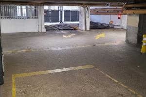 Zone de passage intérieure équipée d'une borne de contrôle lumineuse et de potelets de signalisation jaunes.