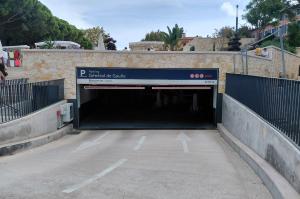Rampe d'accès extérieure menant à l'entrée couverte du parking Général de Gaulle sous une structure en pierre.