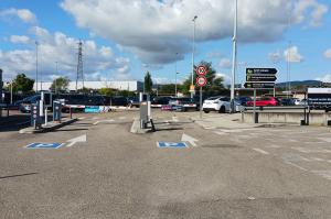 Voies d'accès au parking P1 équipées de bornes de péage automatiques, de barrières et de panneaux de signalisation.