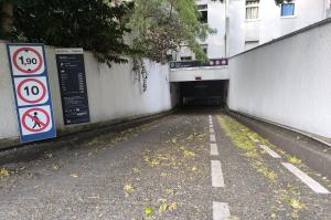 Rampe d'accès descendant vers le parking souterrain Paul Langevin, encadrée par la signalisation des tarifs et de la hauteur maximale.