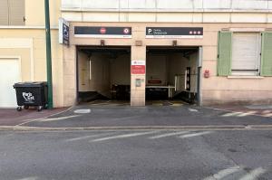 Façade de l'entrée du parking couvert Delacroix avec double voie d'accès et panneau de signalisation.