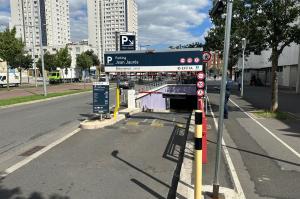 Rampe d'accès extérieure du parking Jean Jaurès avec totems d'information des tarifs et barrières automatiques.