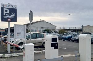 Entrée du parking extérieur avec borne de ticket EFFIA et panneau d'affichage