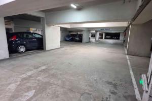 Allée de circulation intérieure d'un parking couvert avec places numérotées.
