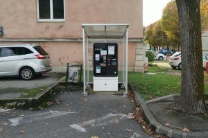 Caisse automatique sous abri située dans une zone de stationnement.
