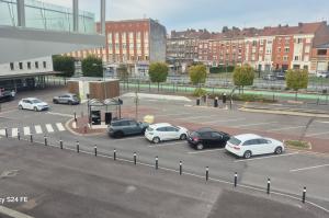 Vue en hauteur du parking extérieur devant des immeubles en brique.
