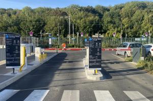 Entrée du parking relais avec barrières automatiques et panneaux tarifaires.