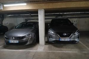 Voitures stationnées sur des places numérotées séparées par un poteau.