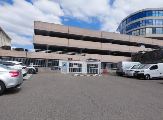 Entrée pour voitures du parking EFFIA Gare de Vienne avec barrières automatiques et marquage au sol.
