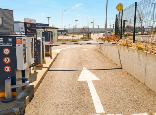 Zoom sur la voie de sortie du parking P2 Mâcon-Loché : l'infrastructure comprend des barrières automatiques, des bornes de paiement par carte et une signalétique tarifaire complète pour faciliter le départ des usagers.