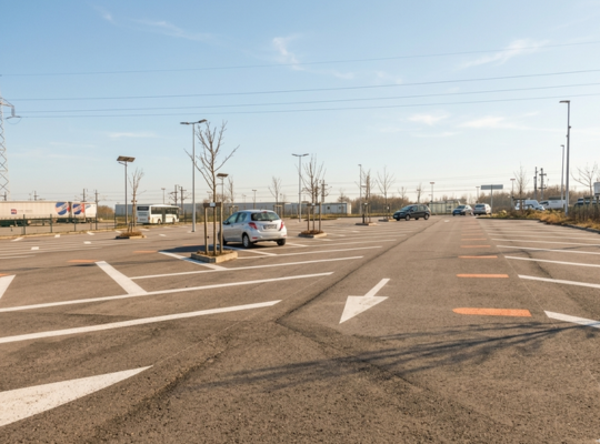 Vue d'ensemble des larges places de stationnement du parking EFFIA P2 à Mâcon-Loché : un espace extérieur propre, bien éclairé et arboré, offrant de nombreuses disponibilités pour les voyageurs TGV.