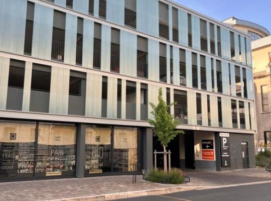 Façade moderne du parking couvert EFFIA Diderot avec ses vitrines de commerces en rez-de-chaussée : l'image montre l'intégration urbaine du bâtiment, la signalétique de l'entrée République et les aménagements piétons attenants.