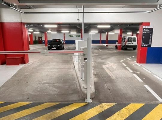 Zoom sur le totem de signalétique et l'entrée République du parking EFFIA : l'image montre le couloir d'accès sécurisé pour les véhicules, situé à côté d'un local commercial au rez-de-chaussée du bâtiment.