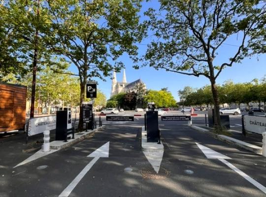 Voie d'accès menant aux équipements de contrôle du parking EFFIA Gare de Châteauroux - Gare Routière : l'image montre le totem noir de signalisation, les barrières automatiques et le marquage au sol guidant les automobilistes à l'entrée du site.