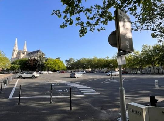 Gros plan sur les bornes de contrôle d'accès automatiques et la barrière de sécurité du parking EFFIA : une infrastructure moderne équipée d'un système de ticket et d'interphonie pour garantir un parcours fluide aux usagers de la gare.