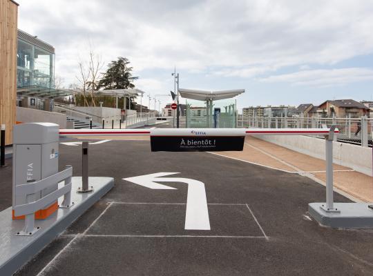 Barrière automatique de sortie du parking EFFIA Gare de Thonon-les-Bains avec marquage au sol et bâtiment d'accueil en fond.
