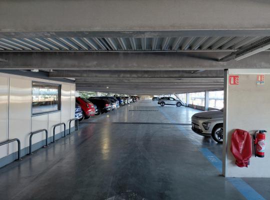 Aperçu d'un niveau couvert et sécurisé du parking EFFIA Lyon Part-Dieu : de grands espaces de stationnement avec marquages au sol précis et équipements de sécurité incendie, garantissant un confort optimal pour garer votre voiture.