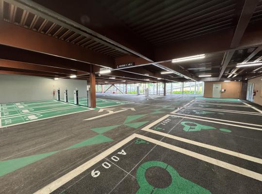 Intérieur du parking EuraPark à Douai : emplacements avec bornes de recharge pour véhicules électriques et places réservées PMR au Niveau 1.