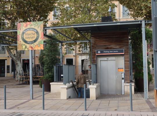 Accès piéton du parking EFFIA Jean Jaurès avec ascenseur PMR et escaliers, situé sur une place ombragée et animée pour un accès direct au centre-ville.