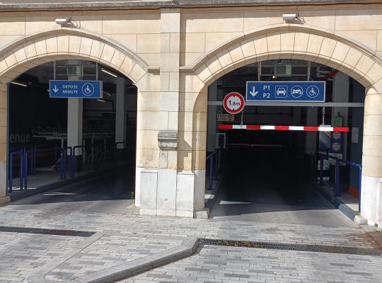 Entrées du parking sous les arches en pierre indiquant les accès au dépose-minute et aux niveaux P1/P2.