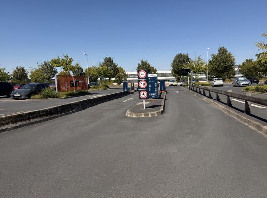Voies d'accès au parking P2 avec panneaux de limitation de vitesse et borne EFFIA.